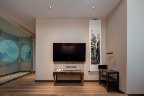 a living room with a flat screen tv on a wall at Ziggy Hotel in Changsha