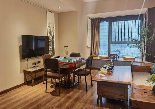 a living room with a table with chairs and a television at Ziggy Hotel in Changsha