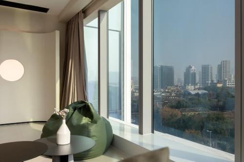a living room with a large window and a table at Ziggy Hotel in Changsha