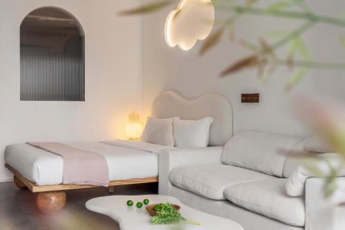 a hotel room with two beds and a couch at Ziggy Hotel in Changsha