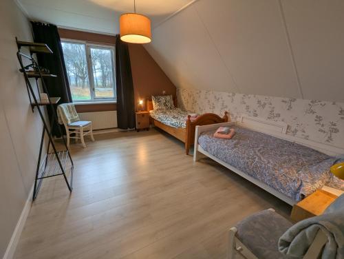 a living room with two beds and a window at Vrijstaande Landelijke Woning in Slagharen