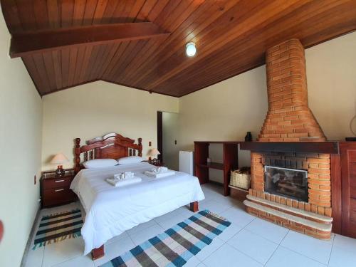 a bedroom with a bed and a fireplace at Pousada Bela Mauá in Itatiaia