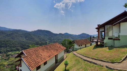 a group of houses with mountains in the background at Pousada Bela Mauá in Itatiaia