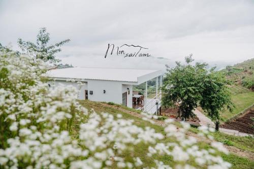 a white building on a hill with white flowers at Mon Sai Lom ม่อนสายลม ม่อนแจ่ม in Mon Jam
