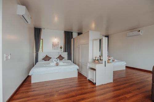 a white bedroom with a bed and a sink at Mon Sai Lom ม่อนสายลม ม่อนแจ่ม in Mon Jam