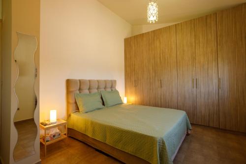 a bedroom with a bed and a wooden cabinet at Villa Vegera in Anavissos
