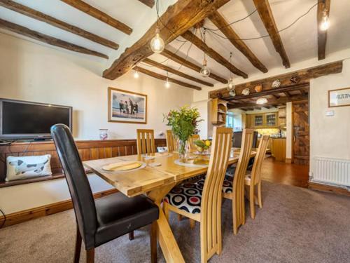 a dining room with a wooden table and chairs at 18th Century Farmhouse, England Wales Border, Breathtaking Views in Oswestry