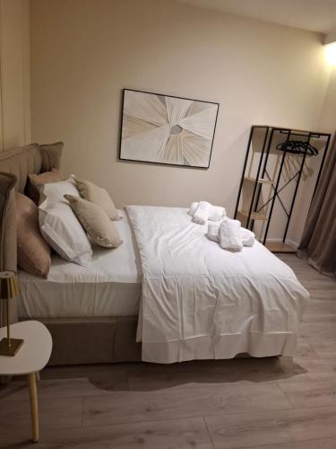 a bedroom with a bed with white sheets and pillows at CastleView Suites in Shkodër