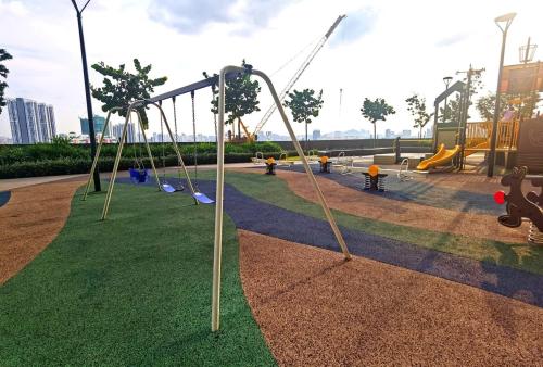 an empty playground with swings and slides in a park at MJ Homestay 99 Batu Caves KL North 99Residence 3R2B in Kuala Lumpur