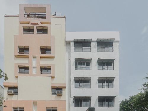an apartment building with balconies on the side of it at Super Hotel O River View Near Shaniwar Wada in Pune