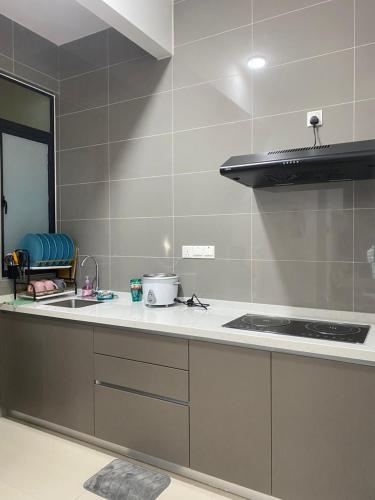 a kitchen with a stove and a counter top at MJ Homestay 99 Batu Caves KL North 99Residence 3R2B in Kuala Lumpur