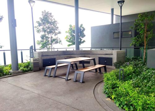a picnic table and benches in a building at MJ Homestay 99 Batu Caves KL North 99Residence 3R2B in Kuala Lumpur