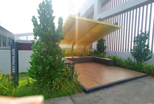 a wooden bench on a deck in front of a building at MJ Homestay 99 Batu Caves KL North 99Residence 3R2B in Kuala Lumpur