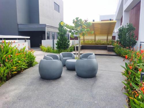 a row of blue chairs sitting in a courtyard at MJ Homestay 99 Batu Caves KL North 99Residence 3R2B in Kuala Lumpur