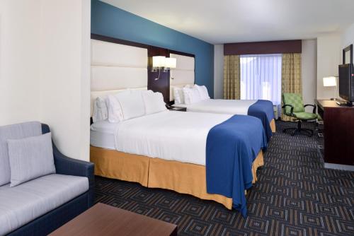 a hotel room with two beds and a couch at Baymont by Wyndham Bessemer in Bessemer