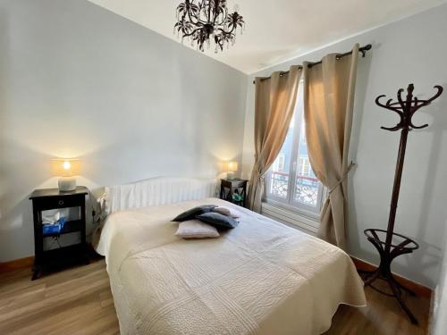 une chambre avec un lit blanc et une fenêtre dans l'établissement Charmant Appartement 16eme, à Paris