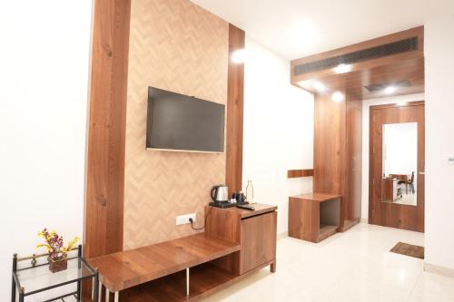 a living room with a television on a wall at Stamps by Eight Continents, Jodhpur in Jodhpur