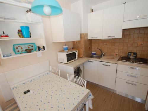 une petite cuisine avec une table et un micro-ondes dans l'établissement Studio climatisé avec terrasse, parking et alcôve – Centre de Menton, proche plages et commerces - FR-1-196-191, à Menton