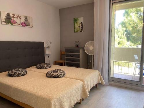 une chambre avec un lit avec deux oreillers dessus dans l'établissement Studio rénové avec parking et wifi à Balaruc-les-Bains - FR-1-553-113, à Balaruc-les-Bains