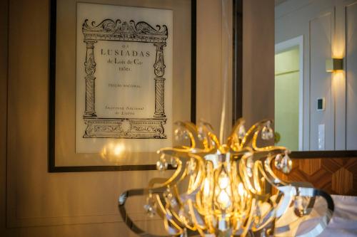 a chandelier in front of a picture on a wall at Azores Book Hotel in Angra do Heroísmo