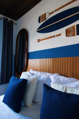 a bedroom with a bed with blue and white pillows at POUSO DE ICARO - POUSADA NO CENTRO de PARATY in Paraty