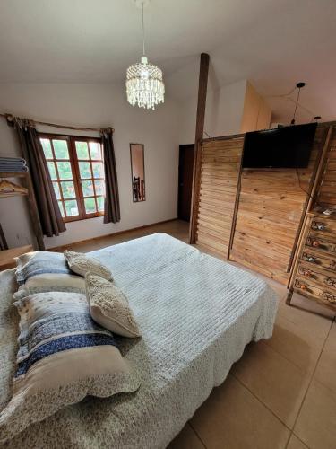 a bedroom with a bed and a flat screen tv at La casita del colibri in Córdoba