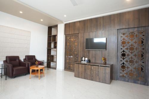 a lobby with a chair and a television on a wall at Stamps by Eight Continents, Jodhpur in Jodhpur