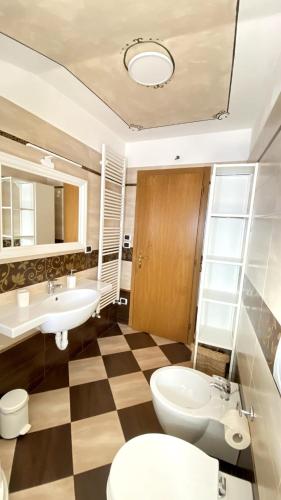 a bathroom with a checkered floor and a toilet and sink at Ciasa Coderoppola in Moena