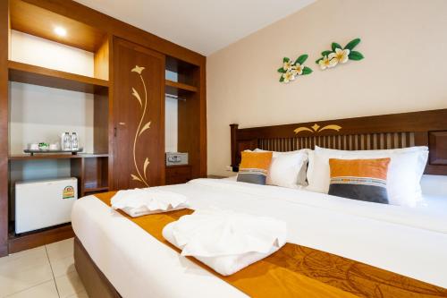 a bedroom with a large white bed in a room at Phuket Leelavadee Hua Ting Resort in Patong Beach