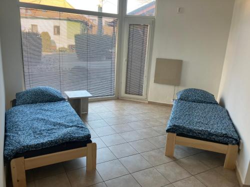 a room with two beds and a large window at Lacné ubytovanie Čadca in Čadca