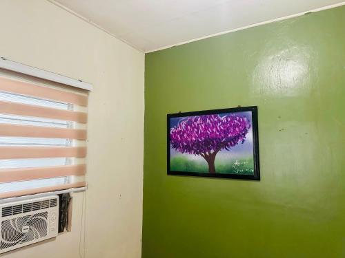 a painting of a purple tree on a green wall at The Alusiman Home - 4 bedroom home in Iloilo City