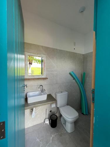 a bathroom with a toilet and a sink at Rancho Celebrai in Caçapava