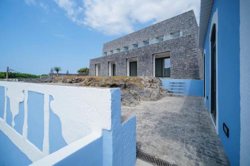 a house on a hill with blue and white walls at Azores Book Hotel in Angra do Heroísmo