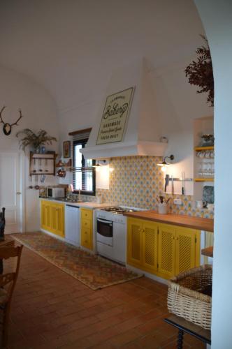 a kitchen with yellow cabinets and a white stove top oven at Villa Lavanda by Época Suites in El Castillo de las Guardas