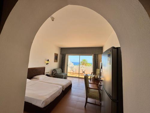 Sultan Sunscape - Premium Sea View Apartment at Domina Coral Bay في شرم الشيخ: غرفة فندقية مع سرير وشرفة