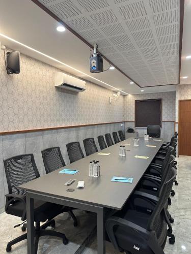 a conference room with a long table and chairs at Bloomax Residency in Malappuram