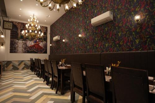 a dining room with tables and chairs and a painting on the wall at Stamps by Eight Continents, Jodhpur in Jodhpur