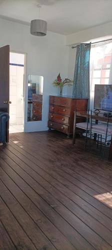 a living room with a dresser and a dining table at Victoria Green Living studio apt in Roseau in Roseau