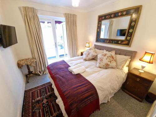 a bedroom with a bed with a mirror and a window at Charming Apartment near Kings Cross in London