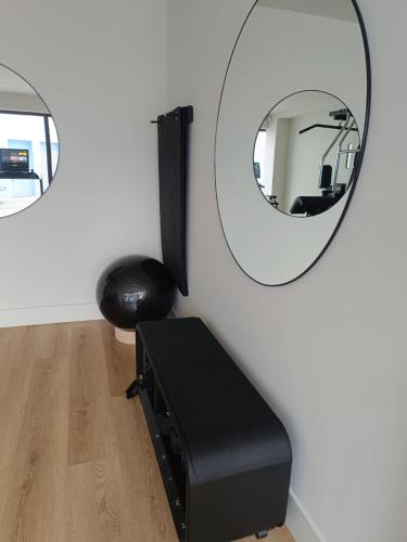 a room with a mirror and a black stool at Azores Book Hotel in Angra do Heroísmo