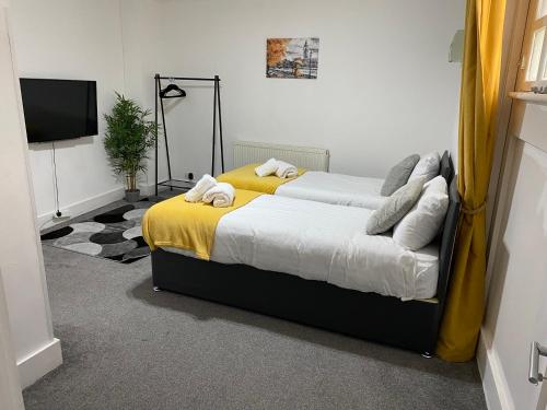 1 dormitorio con 1 cama con manta amarilla en Stylish Cosy 2 Bed Ilford Home with Free Parking, en Ilford