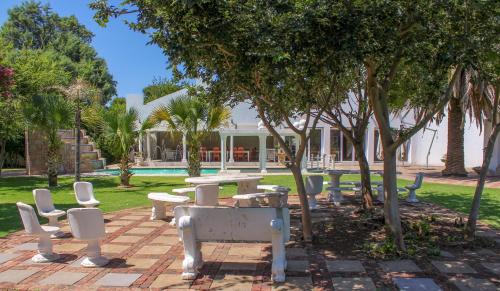 a park with a table and chairs and trees at The Fountain Villa in Klerksdorp