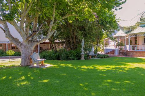 a park with a bench under a tree in a yard at The Fountain Villa in Klerksdorp