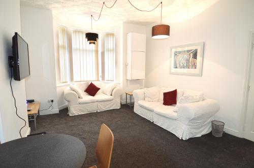 a living room with two white couches and a tv at 3 Person Apartment with Priv Entrance and Carpark in Stockport
