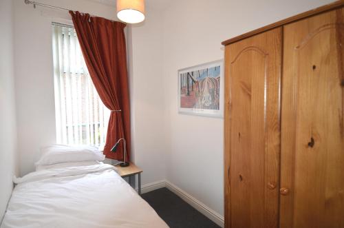 a bedroom with a bed and a window at 3 Person Apartment with Priv Entrance and Carpark in Stockport