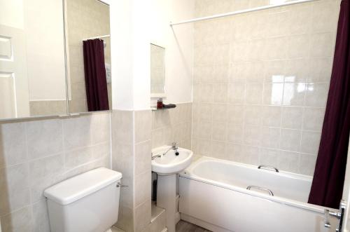 a bathroom with a toilet and a sink and a bath tub at 3 Person Apartment with Priv Entrance and Carpark in Stockport