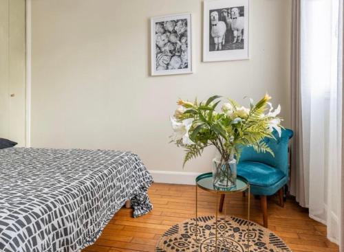 - une chambre avec un vase de fleurs sur une table et un lit dans l'établissement Suites Lyon, à Lyon