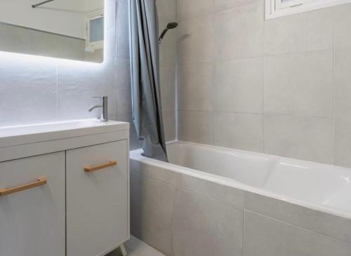 une salle de bain blanche avec un lavabo et une baignoire dans l'établissement Suites Lyon, à Lyon