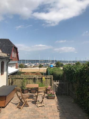 Un patio con mesa y sillas y una valla. en Huset i Grønnegade, en Stubbekøbing