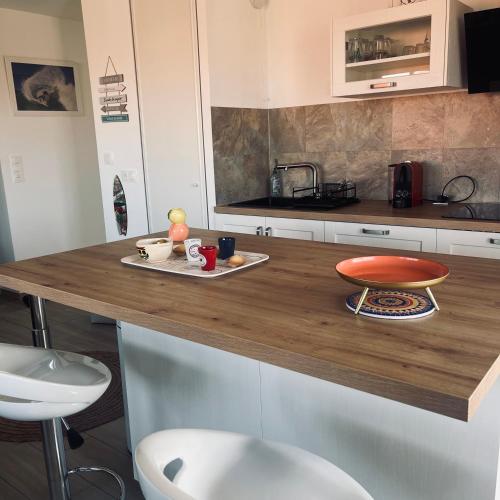 - une cuisine avec un comptoir en bois et une table dans l'établissement F3 à mimizan plage, à Mimizan-Plage